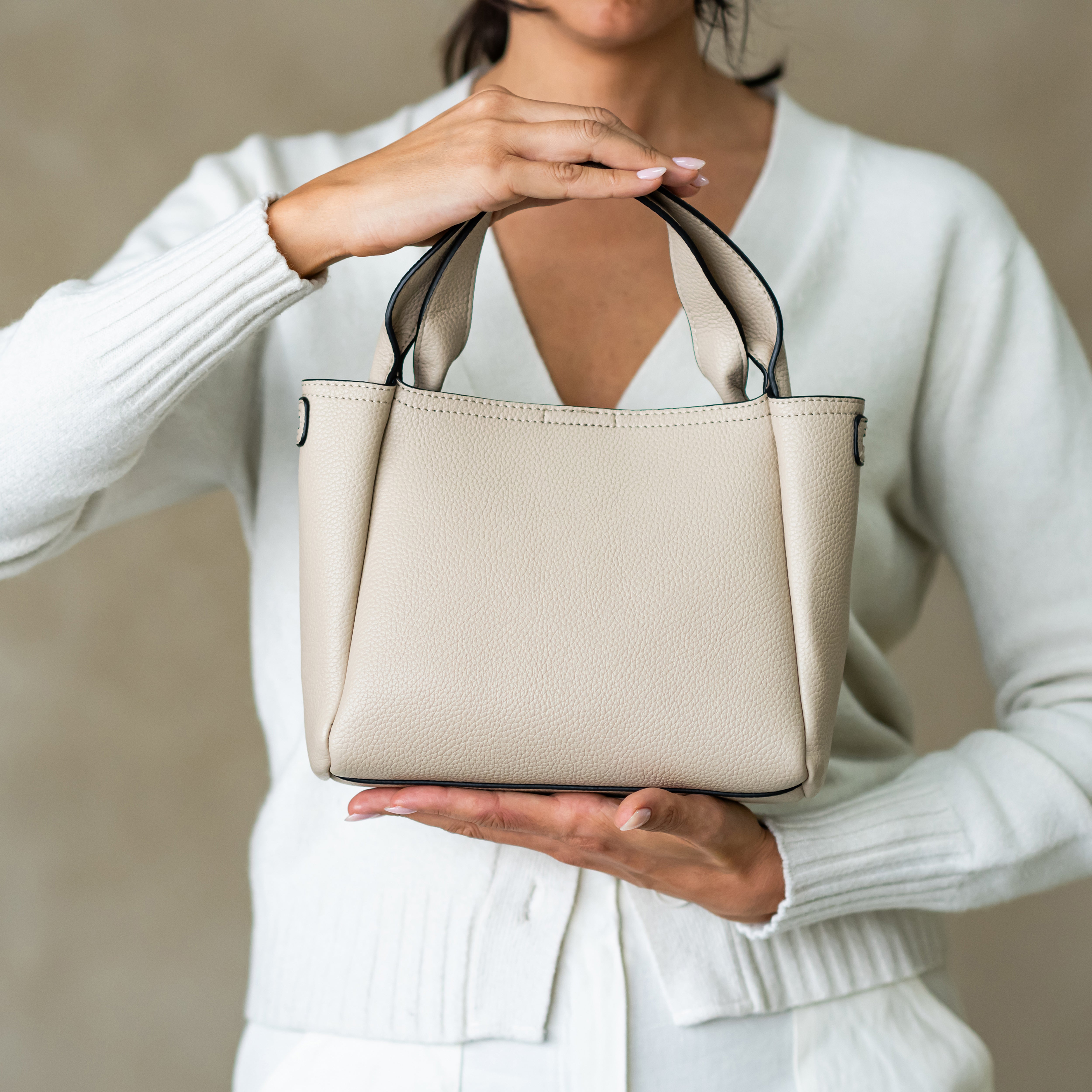 woman holding Sofia top handle satchel bag